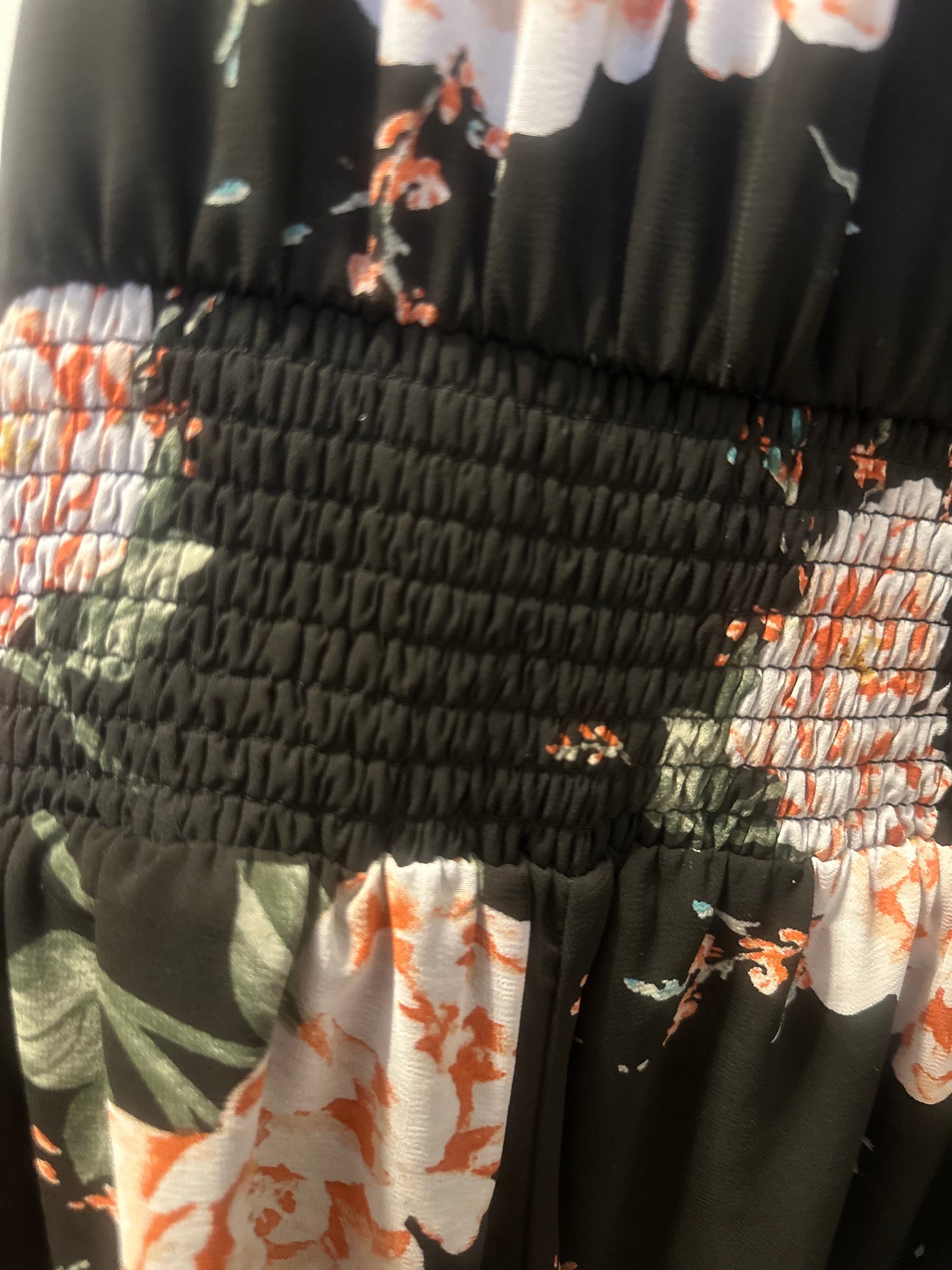 Size 4x (26) Torrid black floral smocked georgette dress with a v-neck and tiered skirt.